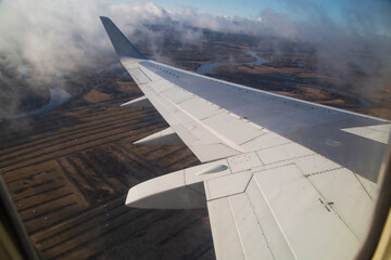 The wing of the plane. View from the porthole.the plane.Flying by plane.