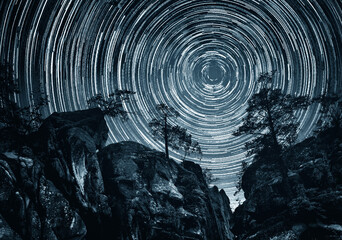 Wall Mural - mountains and trees on starry background with bright stars trails. time lapse, long exposure. elemen