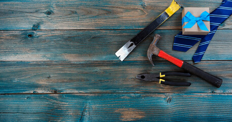 Necktie, tools and giftbox on faded blue wood for happy fathers day concept