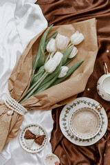 Wall Mural - White tulips  and coffee cup on silky background. Elegant morning, breakfast for woman, valentine day woman day