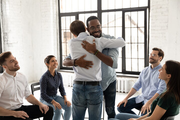 Diverse support community friends hugging on mental health therapy meeting. African American man welcoming teammate after long missing, congratulating on good event , expressing recognition
