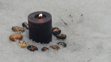 Wall Mural - Burning black candle and runes on stones with copy space.