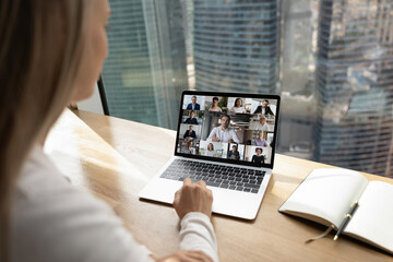 Wall Mural - back view of businesswoman talk speak on video call on laptop in office with multiethnic partners or