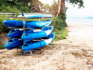 Blue kayaks and a surfing paddle board.