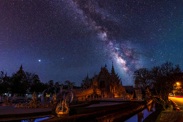 Wall Mural - the milky way galaxy in the sky above wat rong khun, chiang rai, thailand. long exposure photograph,