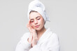 © Volodymyr - Woman applying eye patches. Calm relaxed woman has fresh healthy skin, keeps eyes shut, wears collagen patches under eyes, wears towel on head, gets facial treatment.