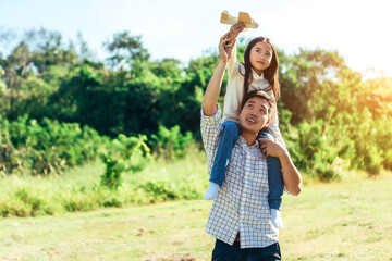 Daughter sits on his father's neck.The family enjoyed a holiday Holiday over beautiful nature.Concept People and family.