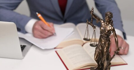 Wall Mural - desk with books and papers, laptop, libra statue and a businessman writing 