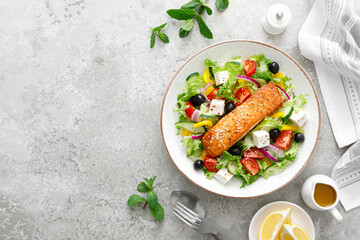 Wall Mural - Salmon fish salad. Fresh vegetable greek salad with tomato, pepper, lettuce, olives, cucumbers, feta cheese and grilled salmon fish fillet, healthy food, omega 3, keto diet, mediterranean cusine