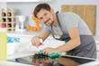 © auremar - smiling man kitchen top with spray bottle detergent