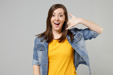 Wall Mural - Young happy excited caucasian woman 20s wear casual trendy denim jacket yellow t-shirt doing phone gesture like says call me back isolated on grey background studio portrait. People lifestyle concept