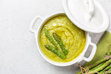 Sticker - Top view of cream of asparagus soup. Prepared with asparagus, potato, onion and vegetable stock. Uncooked ingredient on bacground. Vegan.