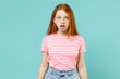 Little shocked amazed redhead kid girl 12-13 years old wearing pink striped t-shirt look camera with open mouth isolated on pastel blue background studio portrait. Children lifestyle childhood concept