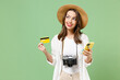 Traveler wistful tourist woman in casual clothes hat camera hold mobile cell phone credit bank card isolated on green background Passenger travel abroad on weekends getaway Air flight journey concept