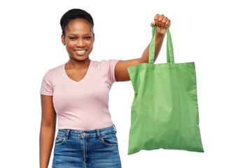 Wall Mural - sustainability and people concept - happy smiling young african american woman with green reusable canvas bag for food shopping over white background