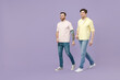 © ViDi Studio - Full length side view two young happy men 20s friends together wearing casual t-shirt walking going strolling isolated on purple color background studio portrait People friendship lifestyle concept.