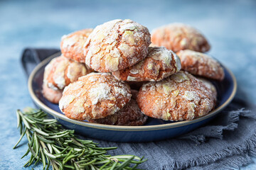 Wall Mural - Homemade orange shortbread crinkle cookies with powdered sugar, rosemary and Sicilian blood oranges on blue concrete background.