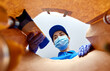 © Syda Productions - health protection and pandemic concept - female delivery worker in protective medical gloves and mask packing food into paper bag