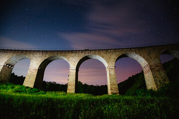 Wall Mural - fantastic starry sky over the old viaduct. long exposure shot, astrophotography.