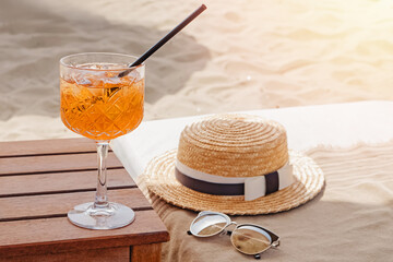 Wall Mural - A glass of aperol Spritz , straw hat and sunglasses on the beach