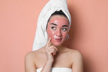 Wall Mural - Woman with pomegranate face mask on pale coral background