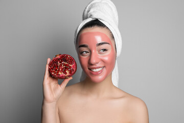 Wall Mural - Woman with pomegranate face mask and fresh fruit on grey background