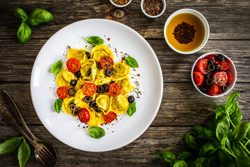 Sticker - Tortelloni stuffed with prosciutto ham and vegetables on wooden table