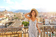 Panoramic view of beautiful smiling woman on terrace in Palermo with cityscape on the background, Sicily, Italy