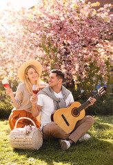 Canvas Print - Lovely couple having picnic in park on sunny spring day