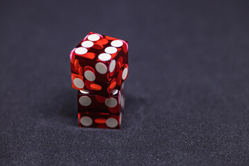 Wall Mural - Two red glass dice on a dark gray background. One lies on top of the other. The result is six. A macro photo with space to copy.