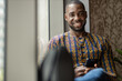 © JonoErasmus - Portrait black African business man smiling, traditional clothing