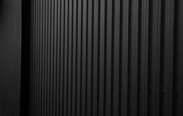 Wall Mural - Black corrugated iron sheet used as a facade of a warehouse or factory. Texture of a seamless corrugated zinc sheet metal aluminum facade. Architecture. Metal texture.