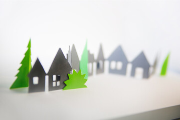 Sticker - Cottages line made of Paper. Paper cut background with buildings and green trees. 