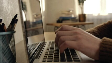 Unrecognizable man browsing laptop at home. Side view of crop male freelancer typing on keyboard of netbook and working on startup project remotely while writing programming code for software 