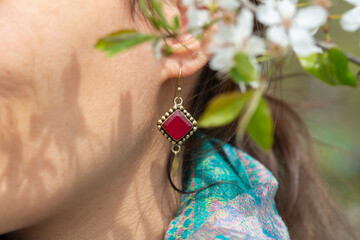 Wall Mural - Close up of woman ear wearing beautiful earrings with mineral gemstone