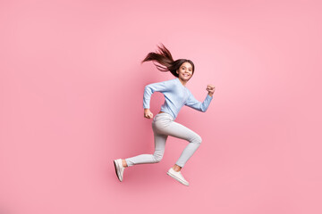 Wall Mural - Full length body size profile side view of lovely cheerful girl jumping running active movement isolated over pink pastel color background