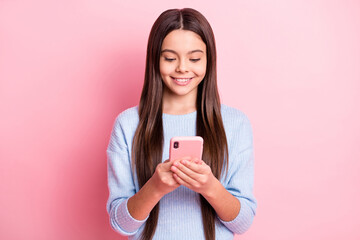 Wall Mural - Portrait of attractive cheerful focused girl using device browsing web isolated over pink pastel color background