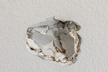 A Hole In The Wall Of A Hallways Caused By A Fist Punching Through The Wall