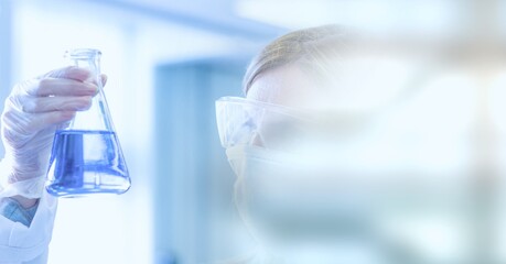 Composition of female scientist holding flask with fluid in lab with motion blur