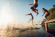canvas print picture - Friends having fun enjoying a summer day swimming and jumping at the lake.