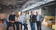 © BullRun - Half length portrait of confident male and female partners looking at camera during collaborative meeting for brainstorming indoors, smart casual executive managers posing during working day