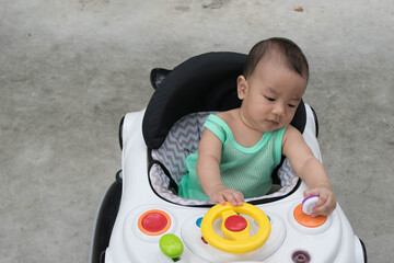 Infant baby sitting walker learns to walk