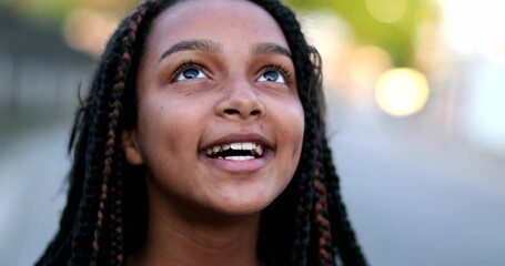 Wall Mural - Happy black preteen girl child face smiling and looking up to sky