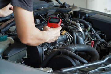 Mechanic is using a diagnostic car code reader.