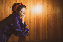 Beautiful Portrait Of Pin Up Young Girl Leaning On A Railing With Violet Dressing Gown, Vintage Mood