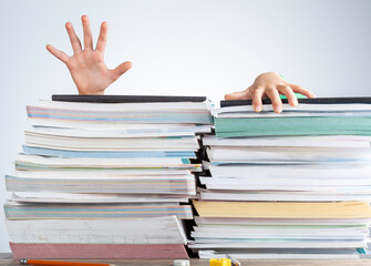Abstract concept image showing a young student behind a large pile of test prep books on a study desk. An overwhelming load. The kid is trying to escape by climbing onto the pile as if she is drowning