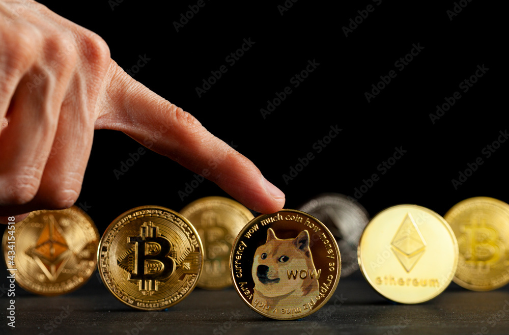 Clarksburg, MD, USA 05-15-2021: Symbolic cryptocurrency types represented as coins are lined up against dark background. Among them dogecoin which started as a joke is currently gaining popularity