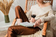 © LIGHTFIELD STUDIOS - cropped view of young woman sitting in rocking chair with book and glass of wine