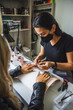 © Francesc Juan/ADDICTIVE STOCK - Master removing gel nail polish of female client with foil sitting at table in spa center