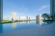 © tampatra - Swimming pool on rooftop of hotel apartment building in Bangkok downtown skyline, urban city view. Relaxing in summer season in travel holiday vacation concept. Recreation lifestyle.